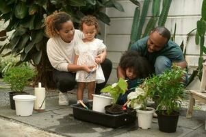 feliz africano americano família desfrutando jardinagem às casa foto