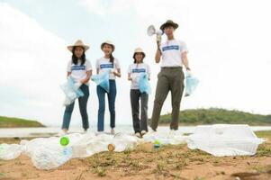 voluntários a partir de a ásia juventude comunidade usando lixo bolsas limpeza acima natureza par foto