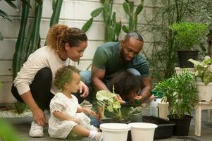 feliz africano americano família desfrutando jardinagem às casa foto