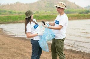 voluntários a partir de a ásia juventude comunidade usando lixo bolsas limpeza acima natureza par foto