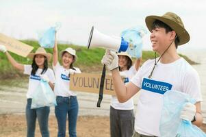 voluntários a partir de a ásia juventude comunidade usando lixo bolsas limpeza acima natureza par foto