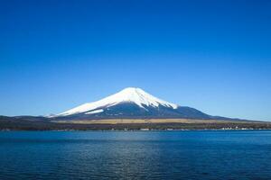 Fuji montanha Visão ao lado lago debaixo azul céu. Japão natural panorama fundo foto