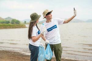 voluntários a partir de a ásia juventude comunidade usando lixo bolsas limpeza acima natureza par foto