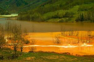 uma lago contaminado com tóxico desperdício dentro a ocidental montanhas do roménia. natureza poluição a partir de cobre meu. ecológico catástrofe ou de Meio Ambiente desastre foto