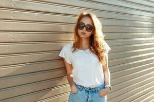 lindo jovem menina dentro Alto cintura jeans perto a vintage de madeira muro. foto