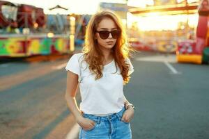 à moda lindo menina dentro oculos de sol às pôr do sol fundo foto