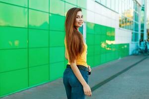 elegante lindo feliz mulher com uma sorrir perto verde parede foto