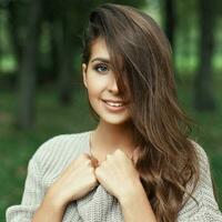 lindo retrato do uma bonita jovem menina com a Penteado sorridente com uma branco sorrir dentro a parque olhando às a Câmera foto