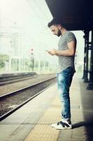 jovem homem às a trem estação. foto