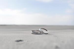 dois Casamento argolas dentro a areia em a fundo do uma de praia e mar. ai gerado foto