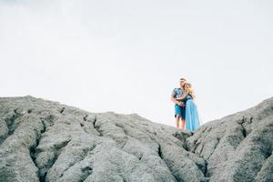 garota loira com um vestido azul claro e um cara com uma camisa leve em uma pedreira de granito foto