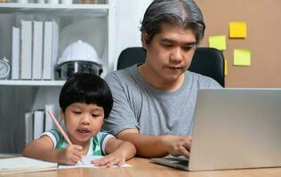 ásia pai é trabalhos às a casa com uma filha e estudando conectados Aprendendo a partir de escola junto. Novo estilo de vida normal durante uma quarentena. conceito do fique lar, freelance e paternidade conceito foto