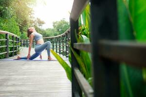 retrato do uma jovem mulher fazendo ioga dentro a jardim para uma dar certo. conceito do estilo de vida ginástica e saudável. ásia mulheres estão praticando ioga dentro a parque. foto
