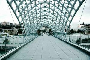 tbilisi, Geórgia, janeiro 08, 2023- pessoas caminhando ao longo a ponte do paz. a moderno arquitetura e famoso ponto de referência dentro tbilisi georgia. foto