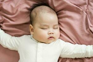 imagem do uma recém-nascido bebê deitado em uma Rosa cama foto