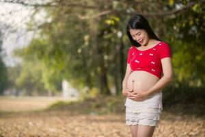 imagem de mulher grávida tocando a barriga com as mãos foto