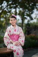 lindo jovem mulher vestindo japonês tradicional yukata foto