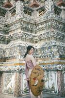 lindo ásia menina dentro tailandês tradicional traje às têmpora foto