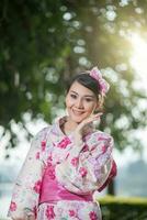 lindo jovem mulher vestindo japonês tradicional yukata foto