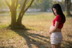 imagem de mulher grávida tocando a barriga com as mãos foto