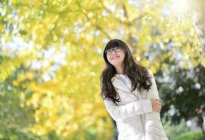 bonita chinês menina vestidos baixa casaco dentro a brilho do sol dia foto