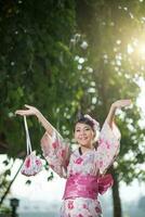 lindo jovem mulher vestindo japonês tradicional yukata foto