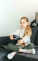 pequeno menina jogando em jogos console foto