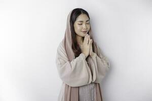 religioso lindo ásia muçulmano menina vestindo uma lenço de cabeça Rezar para Deus, isolado de branco fundo foto