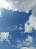 lindas nuvens brancas sobre fundo de céu azul profundo. grandes nuvens fofas e brilhantes cobrem todo o céu azul. foto