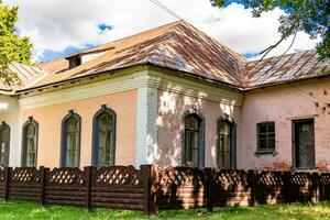 linda e velha casa de fazenda abandonada na zona rural em fundo natural foto