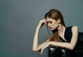 retrato do a elegante mulher dentro Preto vestir tarde Maquiagem e vermelho lábios cinzento fundo foto