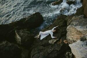 lindo jovem mulher dentro branco Casamento vestir em mar costa molhado cabelo panorama foto