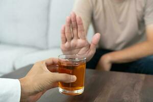 homem recusa dizer não e evitar para beber a álcool uísque , parando mão placa macho, alcoolismo tratamento, álcool vício, Sair bebida, Pare bebendo álcool. recusar vidro licor, pouco saudável, rejeitar foto