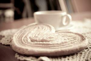 branco copo do Preto café e uma doce amanteigado bolacha em a mesa foto