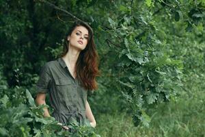 mulher dentro a floresta a atraente Visão do verde folhas dentro a fresco ar foto