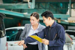 mecânico e jovem mulher cliente falando juntos às a reparar garagem, auto mecânico e fêmea cliente dentro auto reparar comprar, carro reparar e manutenção conceitos foto