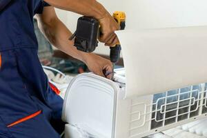 técnico homem instalando ar condicionamento dentro uma cliente casa, reparador fixação ar condicionador unidade, manutenção e reparação conceitos foto