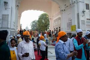 amritsar, Índia - fevereiro 26 2023 - não identificado devotos a partir de vários partes às dourado têmpora - Harmandir sahib dentro amritsar, punjab, Índia, famoso indiano sikh marco, dourado têmpora foto