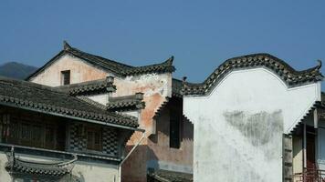 a bela vista da vila tradicional chinesa com a arquitetura clássica e árvores verdes frescas como pano de fundo foto