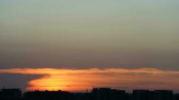 a lindo pôr do sol Visão com a edifícios' silhueta e laranja cor céu Como fundo dentro a cidade foto