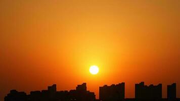 a lindo pôr do sol Visão com a edifícios' silhueta e laranja cor céu Como fundo dentro a cidade foto