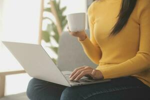 jovem adulto feliz sorridente estudante asiático latino-americano usando fones de ouvido falando na reunião de bate-papo on-line usando laptop no campus universitário ou no escritório virtual. estudante universitária aprendendo remotamente. foto