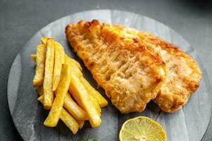 profundo frito peixe e salgadinhos francês fritas velozes Comida refeição Comida lanche em a mesa cópia de espaço Comida fundo rústico topo Visão foto