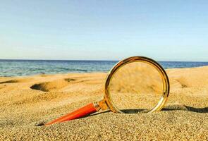 uma lupa em a areia foto