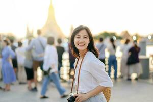 retrato jovem lindo ásia mulher sorridente enquanto viagem às wat uma corrida pôr do sol Visão apontar, Bangkok, tailândia. foto