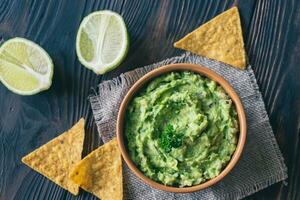 tigela de guacamole com chips de tortilha foto