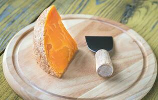 queijo mimolette na tábua de madeira foto