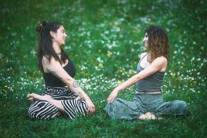 casal do jovem mulheres Veja às cada de outros durante uma ioga sessão foto