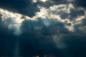 ameaçador dramático céu com Sombrio nuvens e raios do verão Sol foto