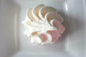 pequeno branco saboroso doce merengue em uma branco prato foto